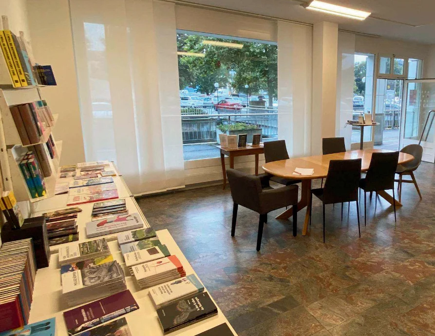 Der helle Verlagsraum mit Buchpräsentationen, Sitzplätzen und grosser Fensterfront.